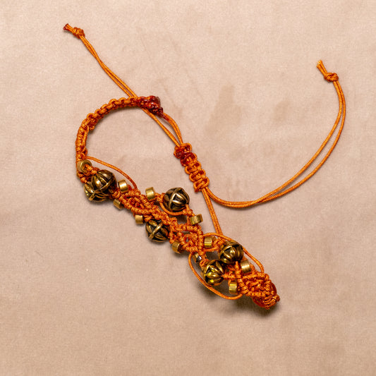 Koperkleurige macramé-armband met goudkleurige kralen