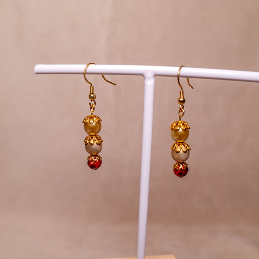 Oorbellen met bronskleurige en granaatappelrode kralen