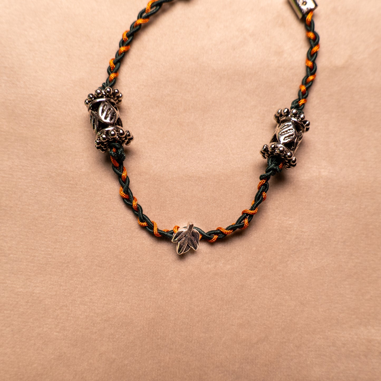 Gevlochten armband donkergroen en koperbruin met metalen kralen