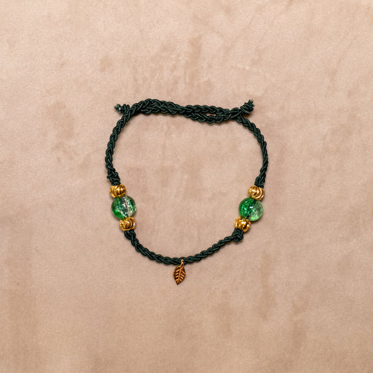Gevlochten donkergroene armband met gekraakte kralen en goudkleurig blaadje