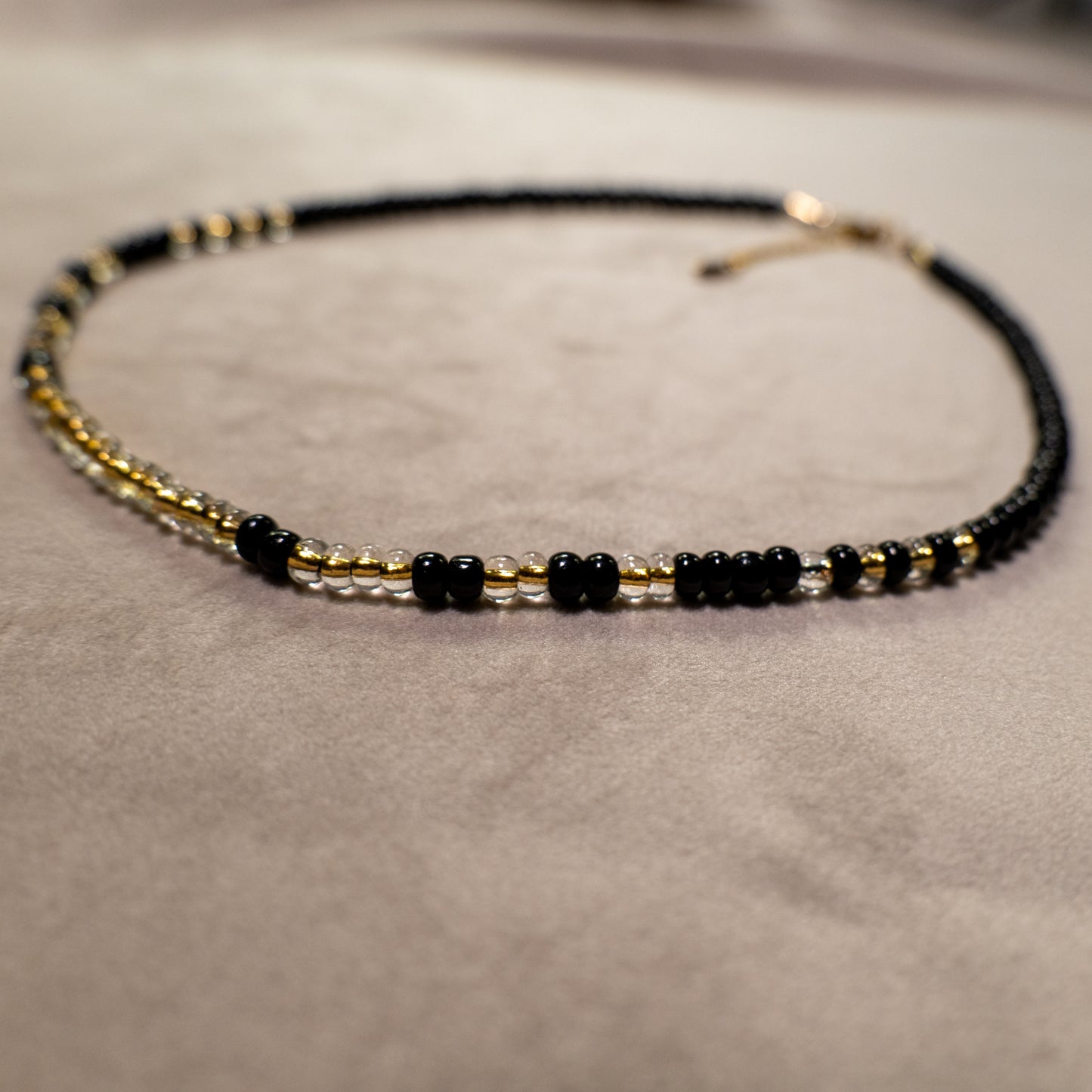 Ketting met mat zwarte rocailles en transparante kralen met gele kern