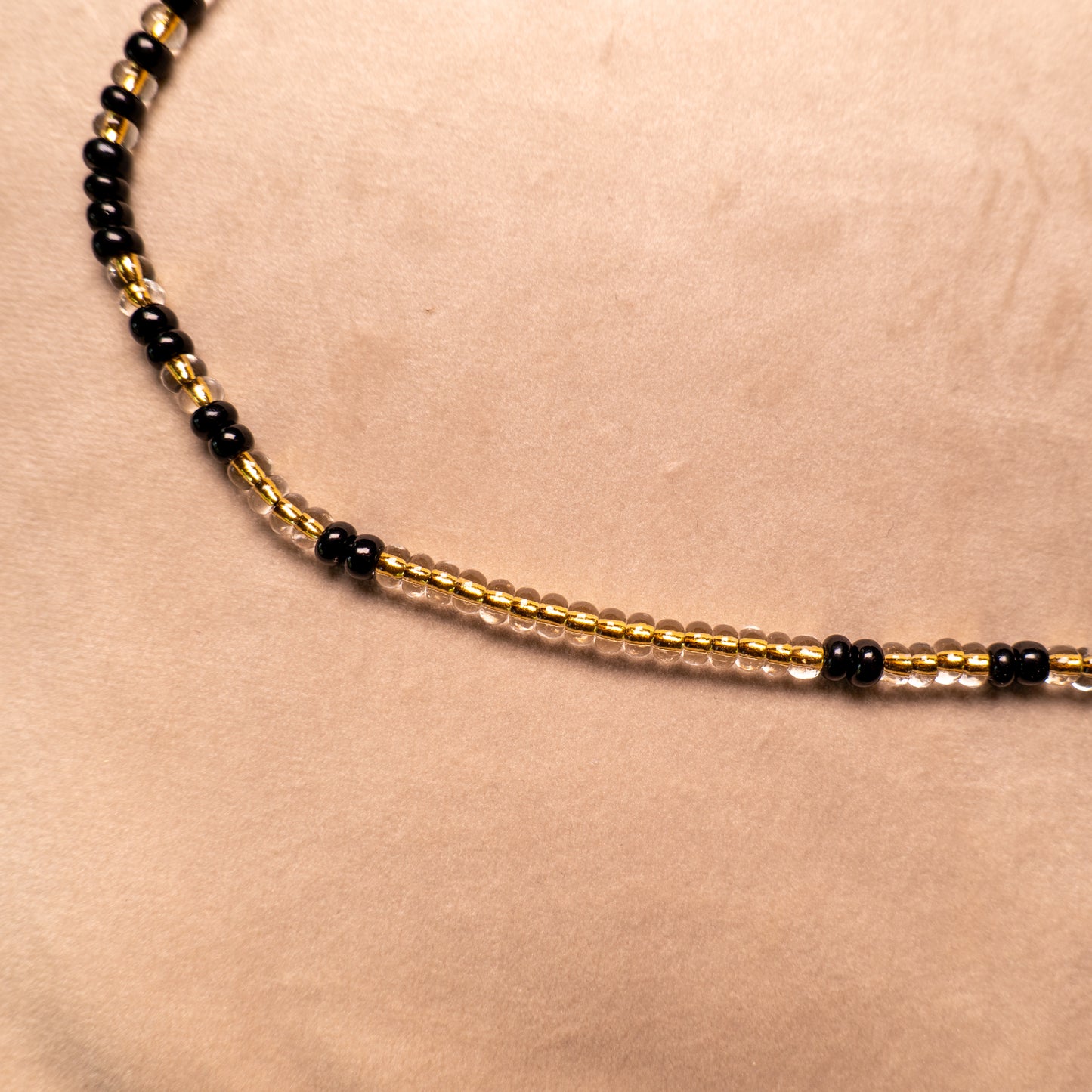 Ketting met mat zwarte rocailles en transparante kralen met gele kern