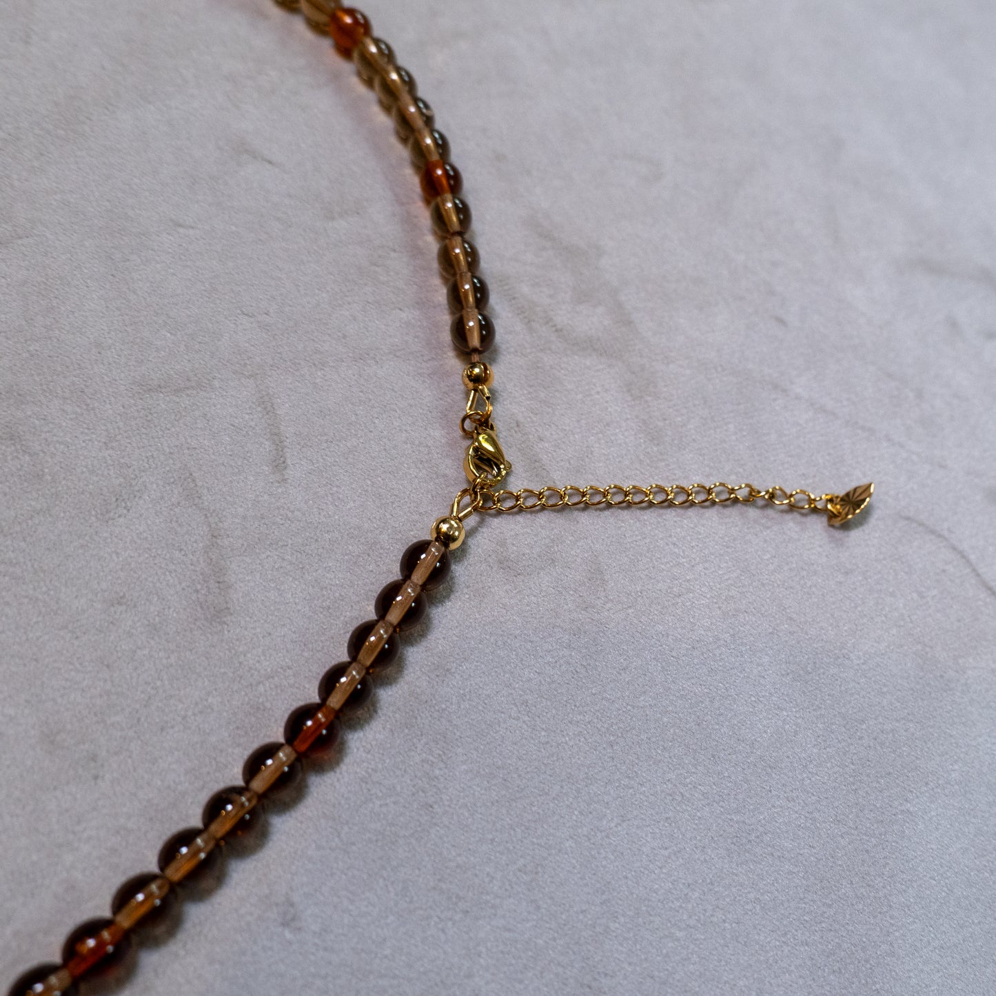 Een close up van de goudkleurige sluiting en verlengketting.