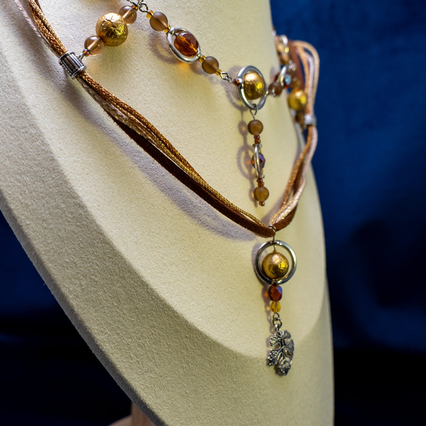 Ketting met blad-hanger, bruin lint en goudkleurige kralen