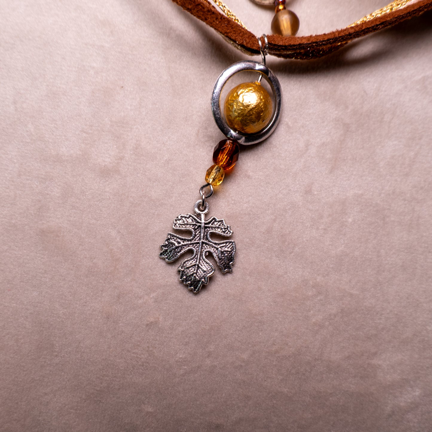 Ketting met blad-hanger, bruin lint en goudkleurige kralen