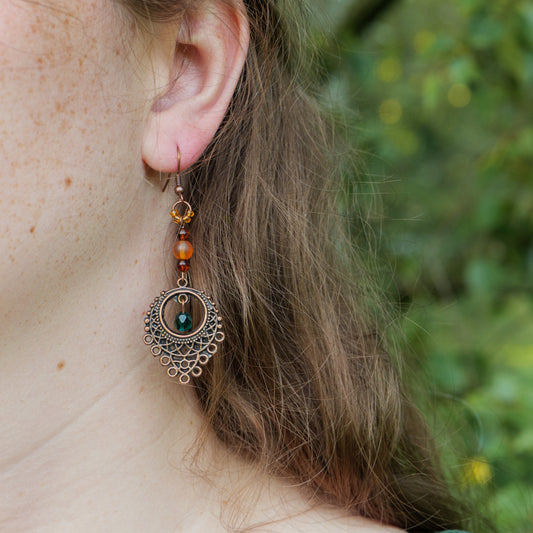 Oorbellen met antiek koperkleurig ornament en oranje en groene kralen