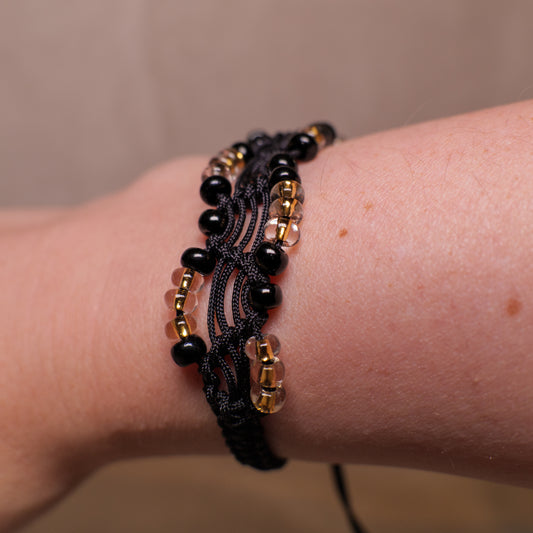 Zwarte macramé-armband met mat zwarte en transparante kralen met gele kern