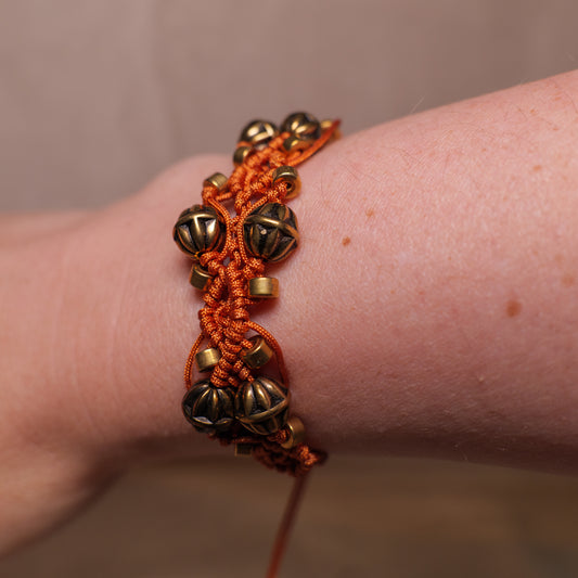 Koperkleurige macramé-armband met goudkleurige kralen