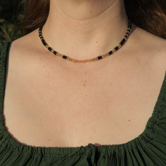 Ketting met mat zwarte rocailles en transparante kralen met gele kern