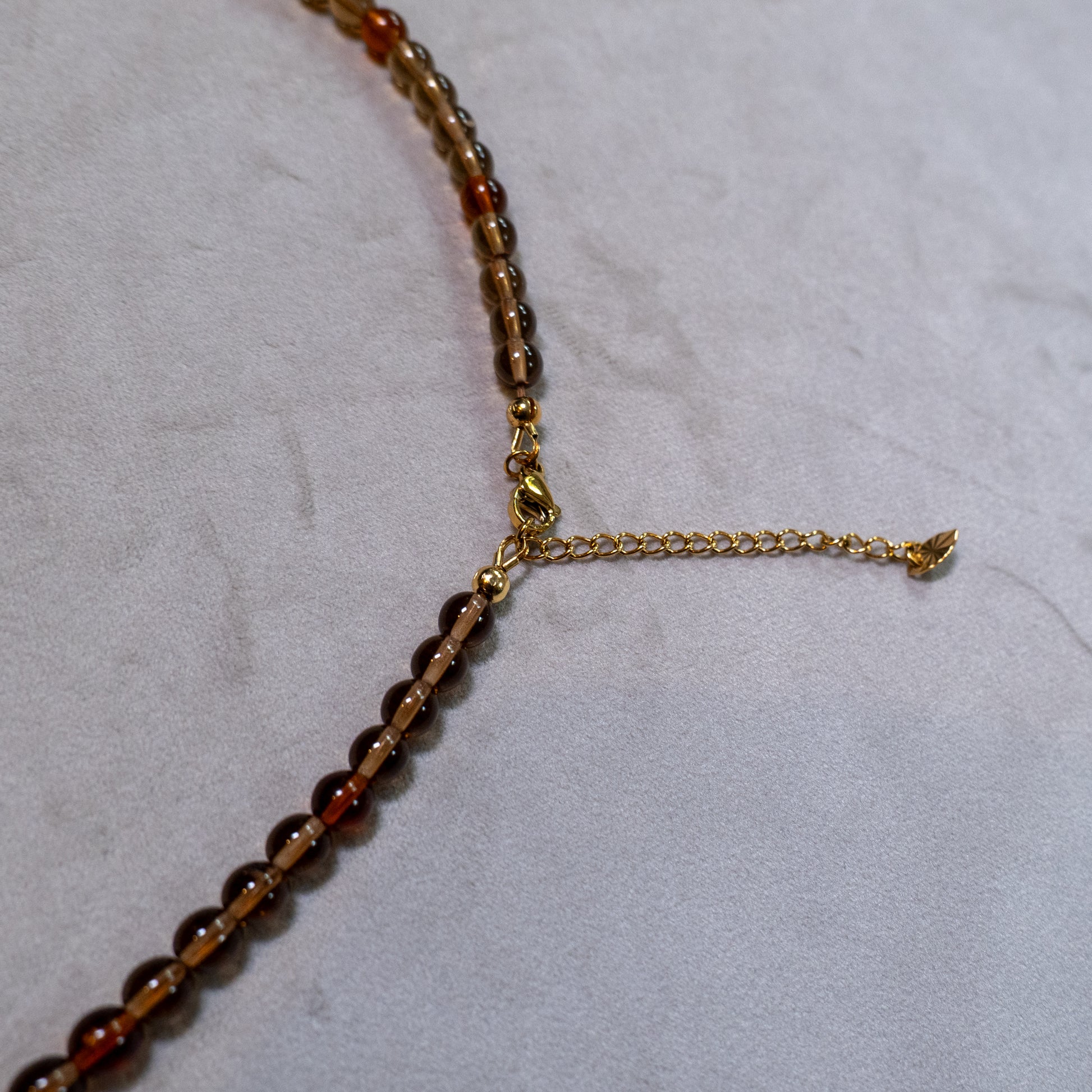 Een close up van de goudkleurige sluiting en verlengketting.
