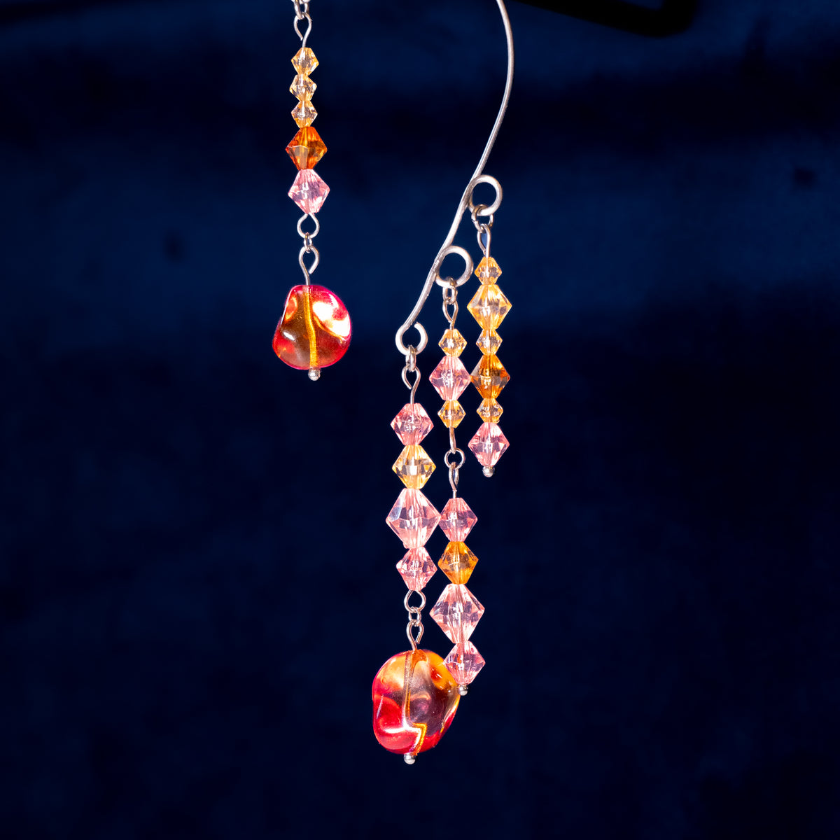 Ear cuffs herfstzon op een blauwe achtergrond. Met oranje en roze kralen.