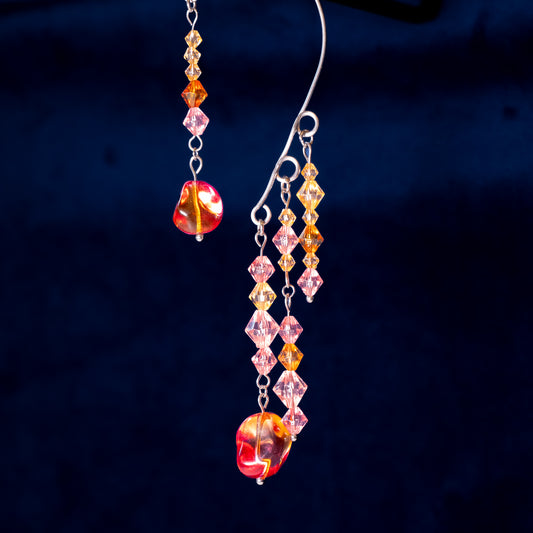 Ear cuffs herfstzon op een blauwe achtergrond. Met oranje en roze kralen.