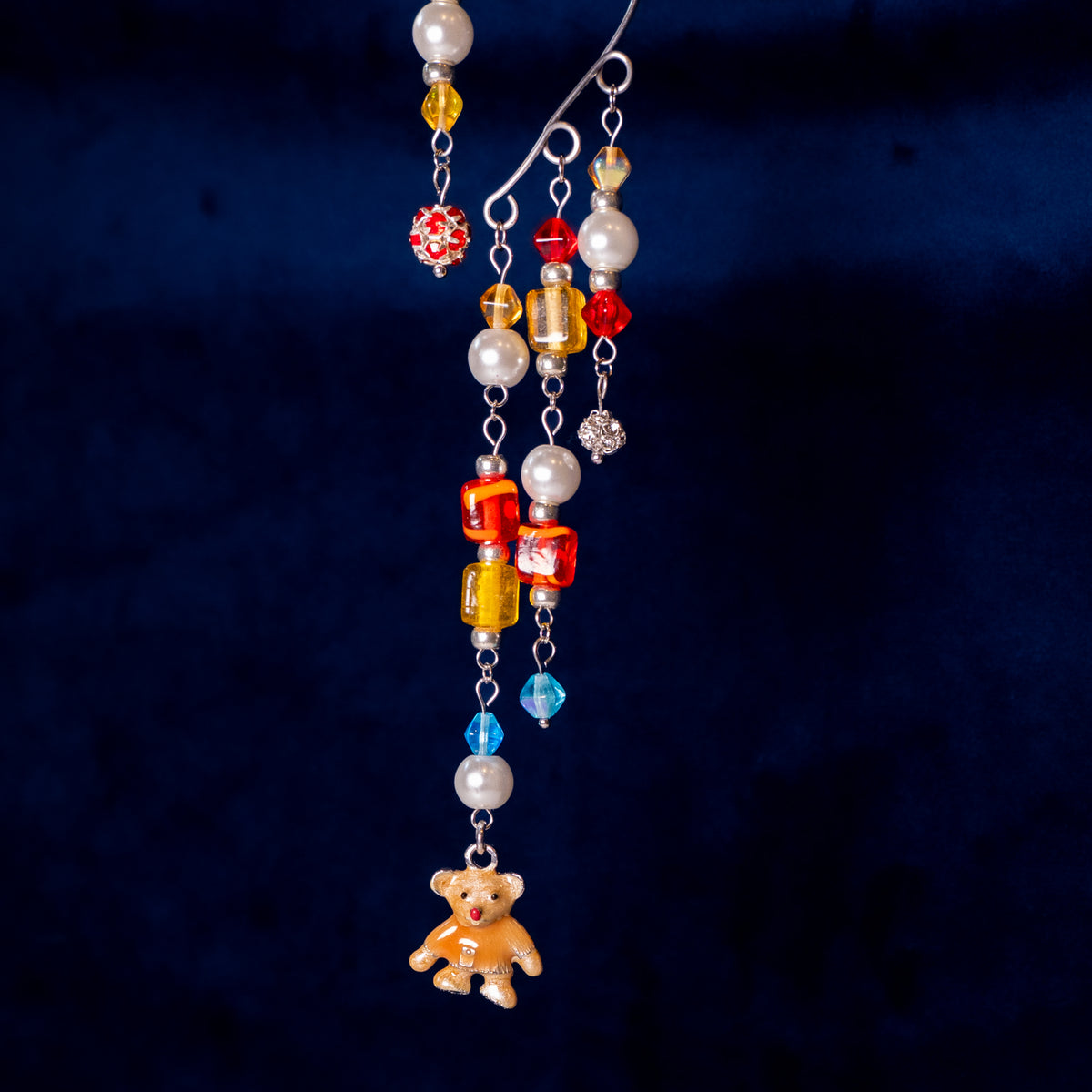 Ear cuff speelgoedkist met beer op donkerblauwe achtergrond.