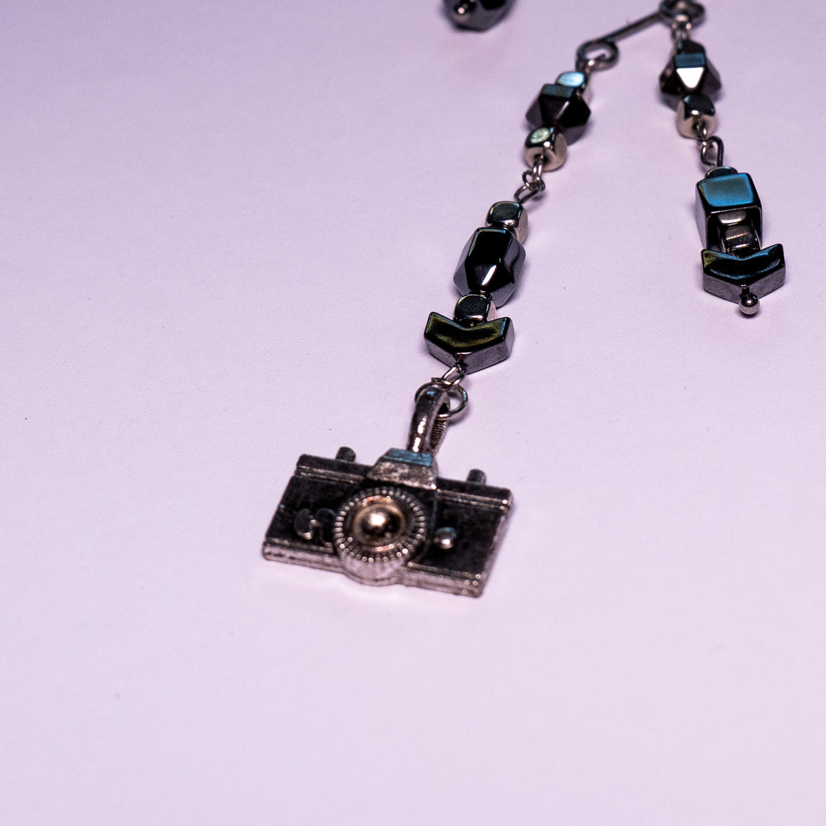 Detailfoto camera ear cuff op witte achtergrond