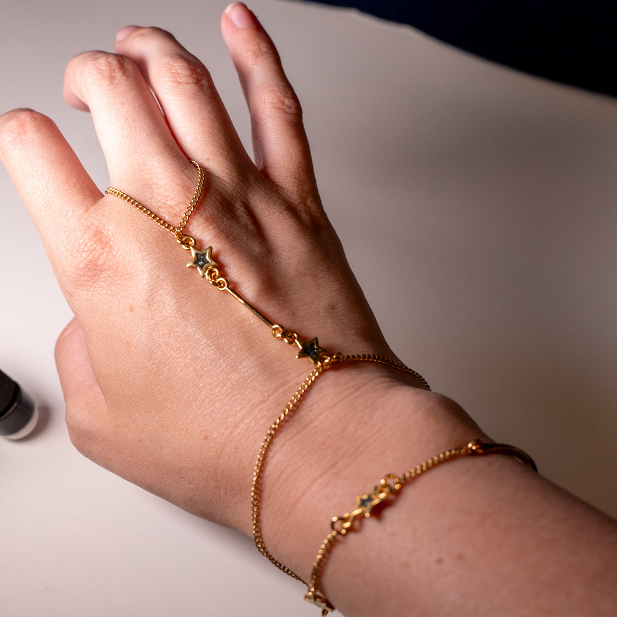 Starlit Path Hand Chain | Goudkleurige handsieraad met zwarte sterren